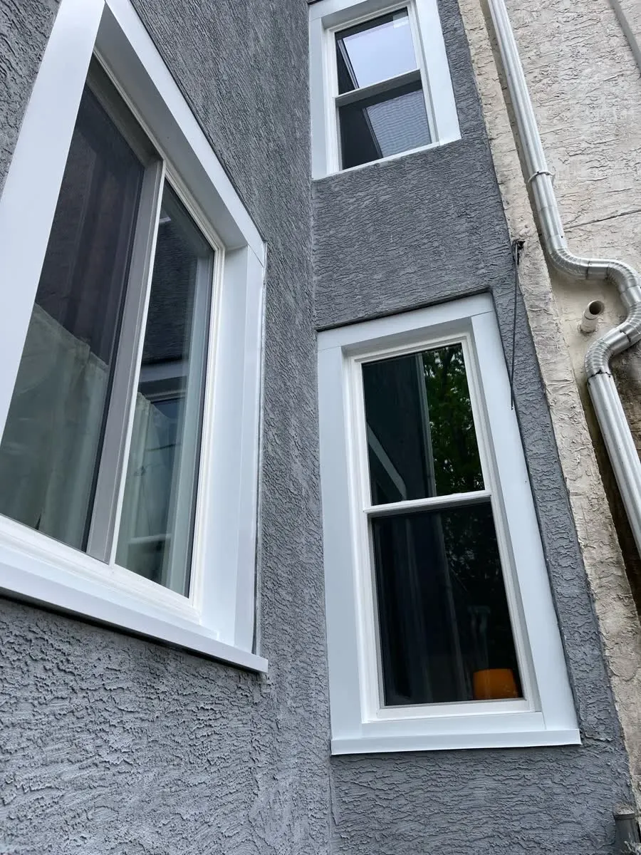 The same rowhome after with new white-trimmed windows